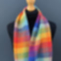 Multicolored checkered scarf displayed on a black mannequin against a gray background, showcasing vibrant rainbow hues and textured fabric.