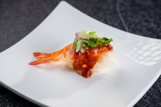 Spicy shrimp sushi on white plate