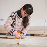 A Wills Marquees craftswoman cutting canvas in the workshop in Yorkshire, UK