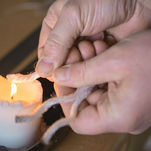A Wills Marquees craftsperson heat seals rope using a candle