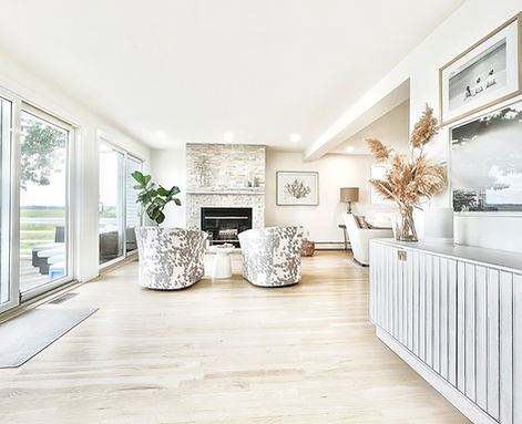 An interior view of a renovated living space featuring a stacked stone fireplace.