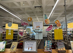 Photo of window with fruit decorations and sign with theme of the month