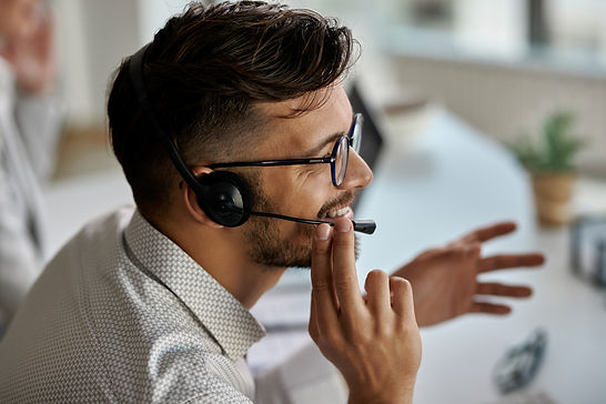 happy-call-center-agent-wearing-headset-while-talking-with-clients-working-office.jpg