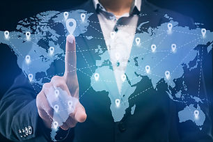 Businessman touching location on worldwide business map proected on interactive screen, wo