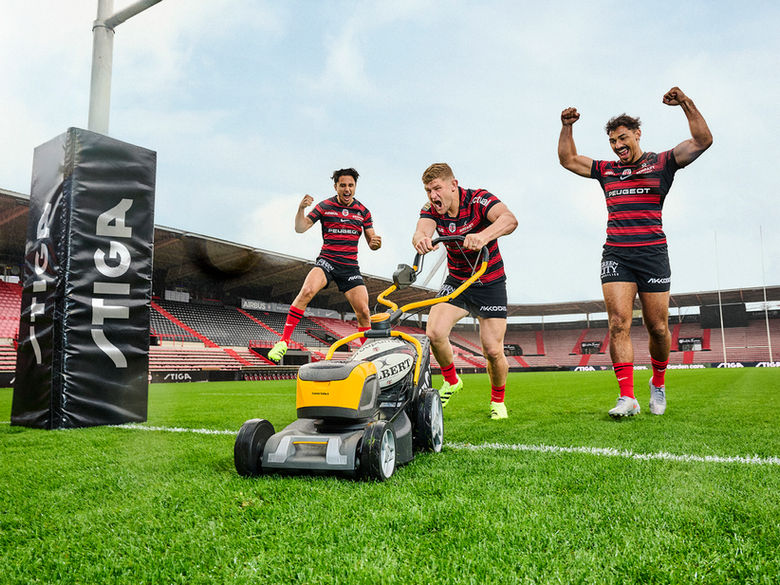 Joueurs du Stade Toulousain célébrant un essai sur la pelouse d un stade de rugby autour d une tondeuse STIGA avec ballon Gilbert lors d une campagne publicitaire sport produite par Marker Production