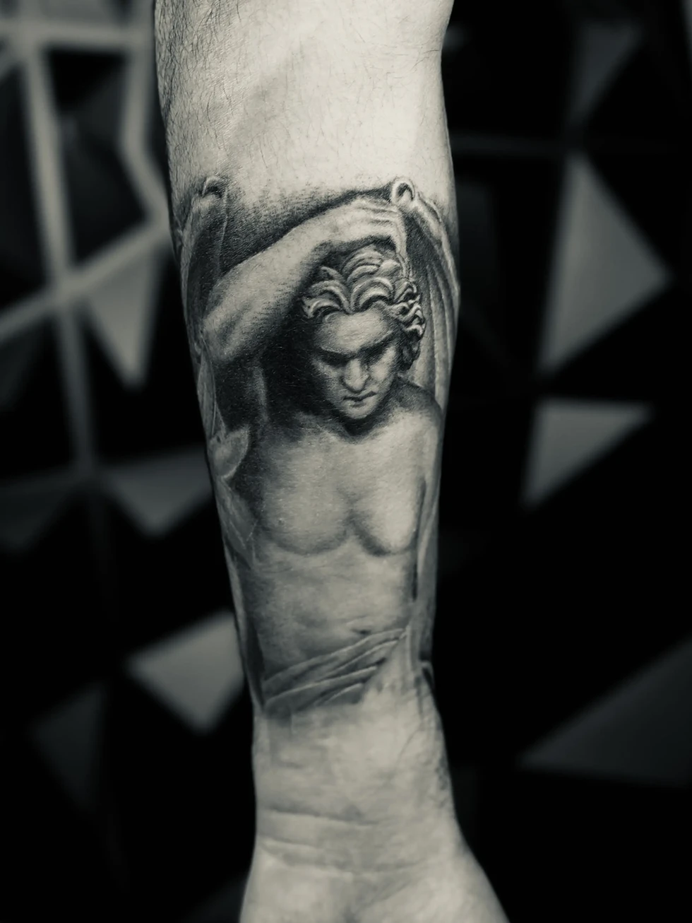 Inspired by the classical sculpture and masterpiece, this black and grey piece by Joker Ink translates the beauty of the original marble to human skin