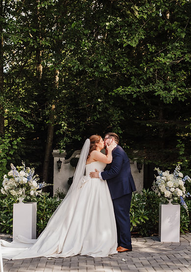 Romantic outdoor wedding portrait beneath garden arbors at Jackson Manor Events wedding venue