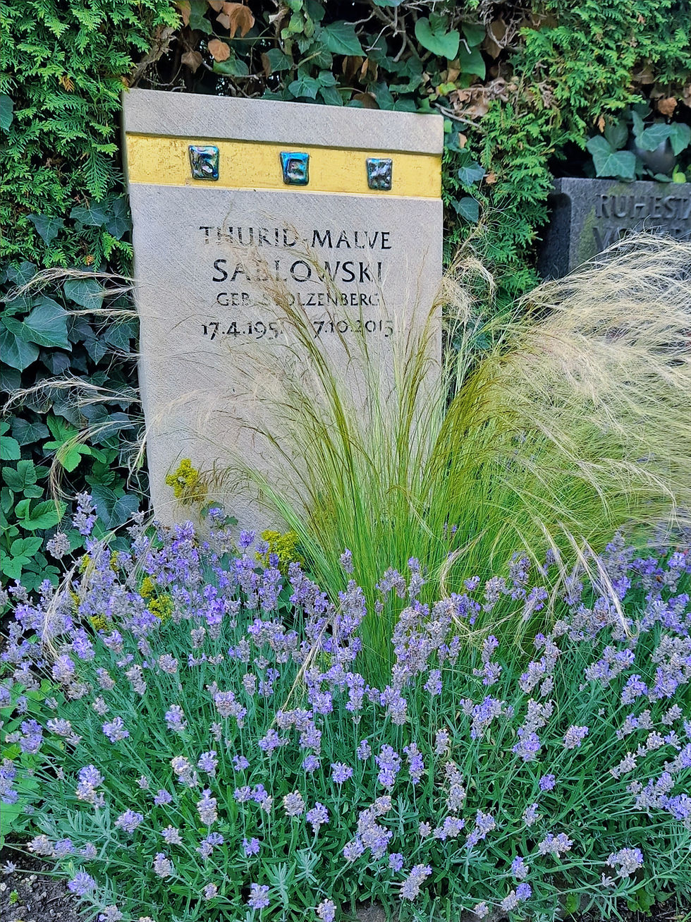 Urnengrab mit üppig blühender Lavendel-Grabbepflanzung im Sommer