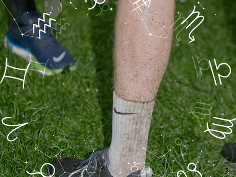 Close up of runner's feet stood on grass with astrology signs 