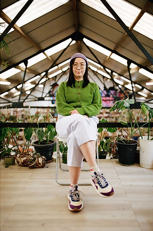 Photo of Susi Huang sitting in a chair in the studio, photo by Youmustcreate