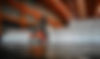 A forklift operator transports a large Six Star Bulk Bag in a spacious warehouse. The warehouse is filled with neatly stacked white bulk bags under an orange steel roof structure. The Six Star Bulk Bag logo and text 'since 1986' are prominently displayed in the lower right corner, emphasizing the company's long-standing presence in the bulk bag industry.