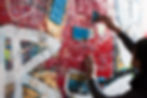 Pessoa passando massa corrida colorida na parede e transformando em arte