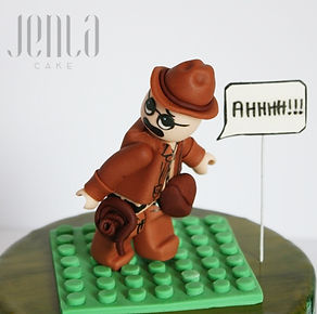How do you combine 3 different themes intoone cake? You don't, you create 3 different cakes that have a common theme. Knitting cake with yarn is about to roll over Lego Indiana Jones (with some Settlers of Catan in there) while a rugby player tries to shout a warning!