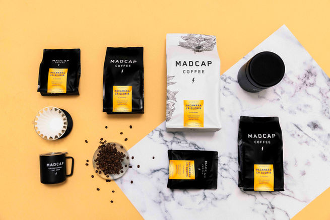 several bags of madcap coffee sit on a table