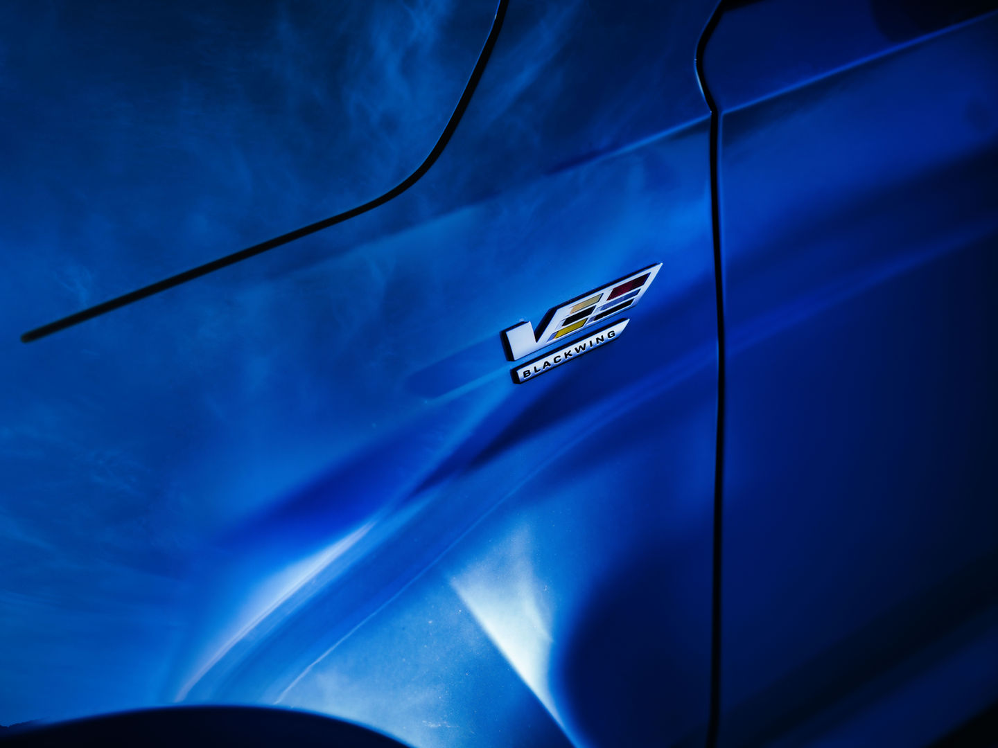 a blue car has a black wing emblem on the side