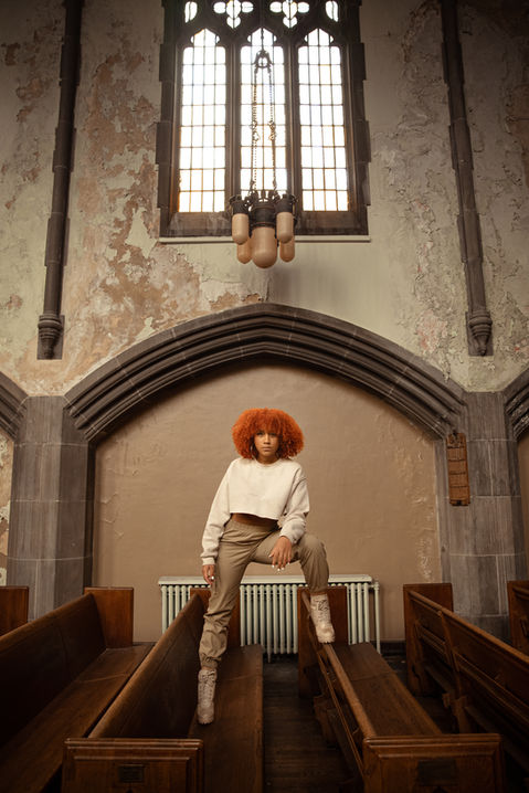 a woman with red hair is sitting on a bench in a church