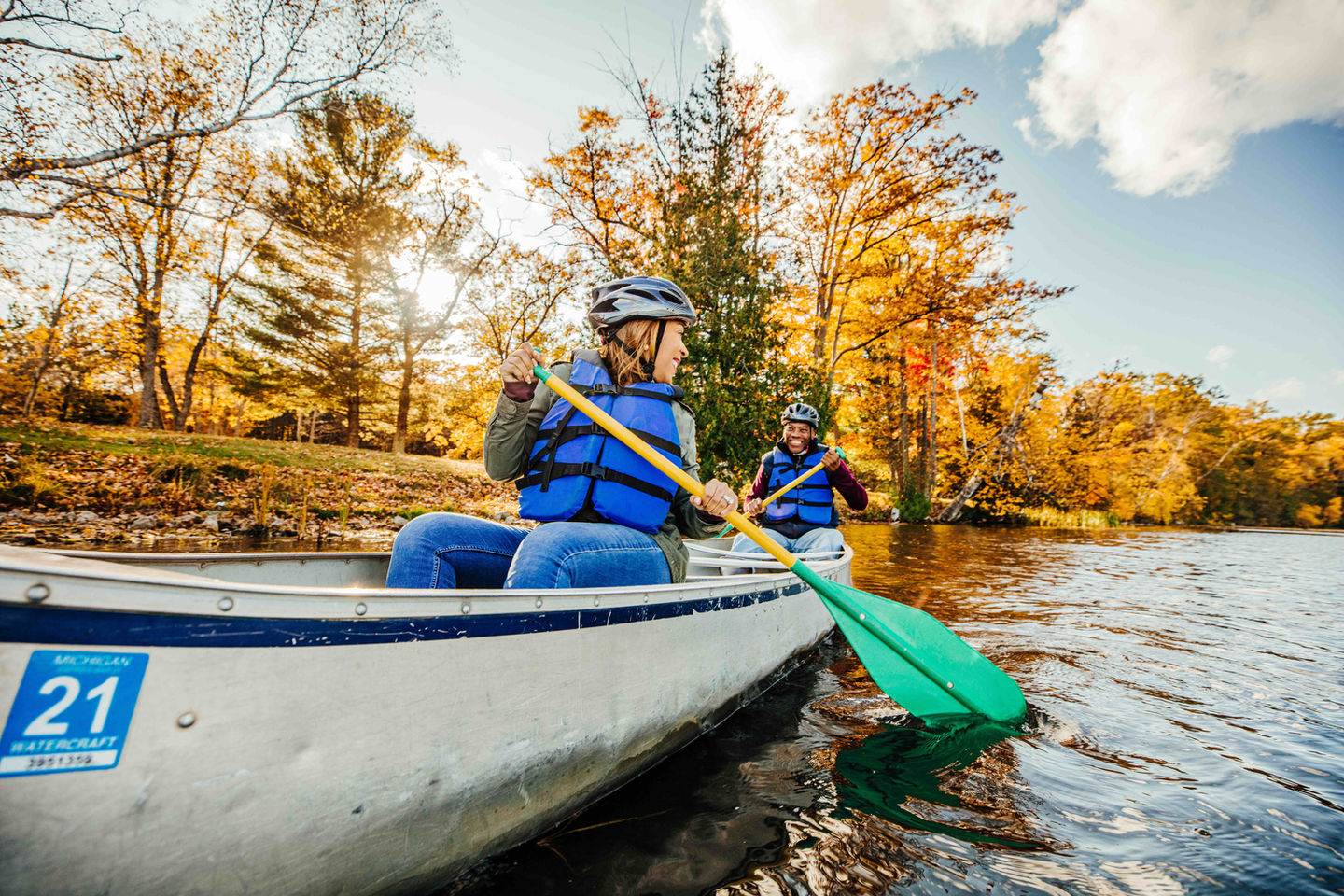 a man and a woman are paddling a canoe on a river