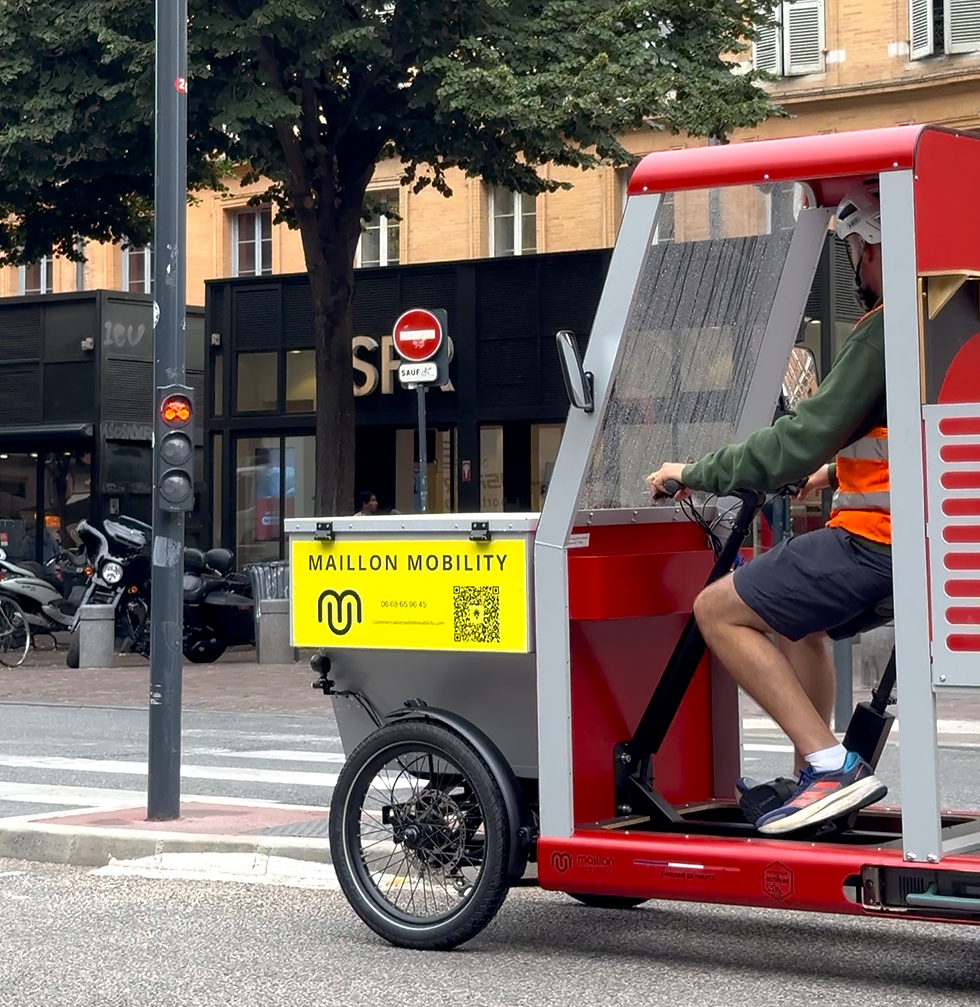 Vélo cargo couvert arrêté à un feu rouge