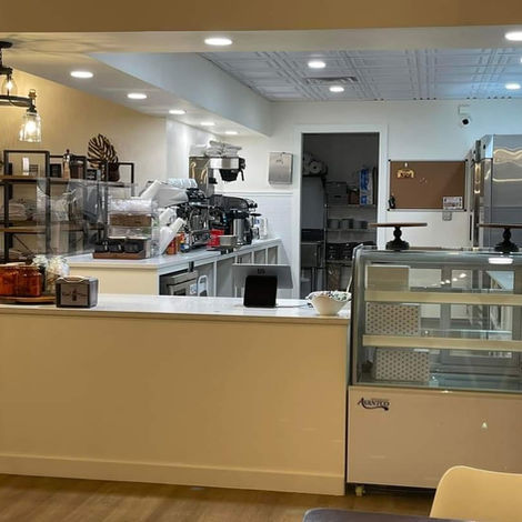 Modern cafe counter with display case, white interior renovation Galveston TX.