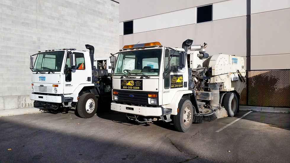Two street sweepers in a municipal setting.