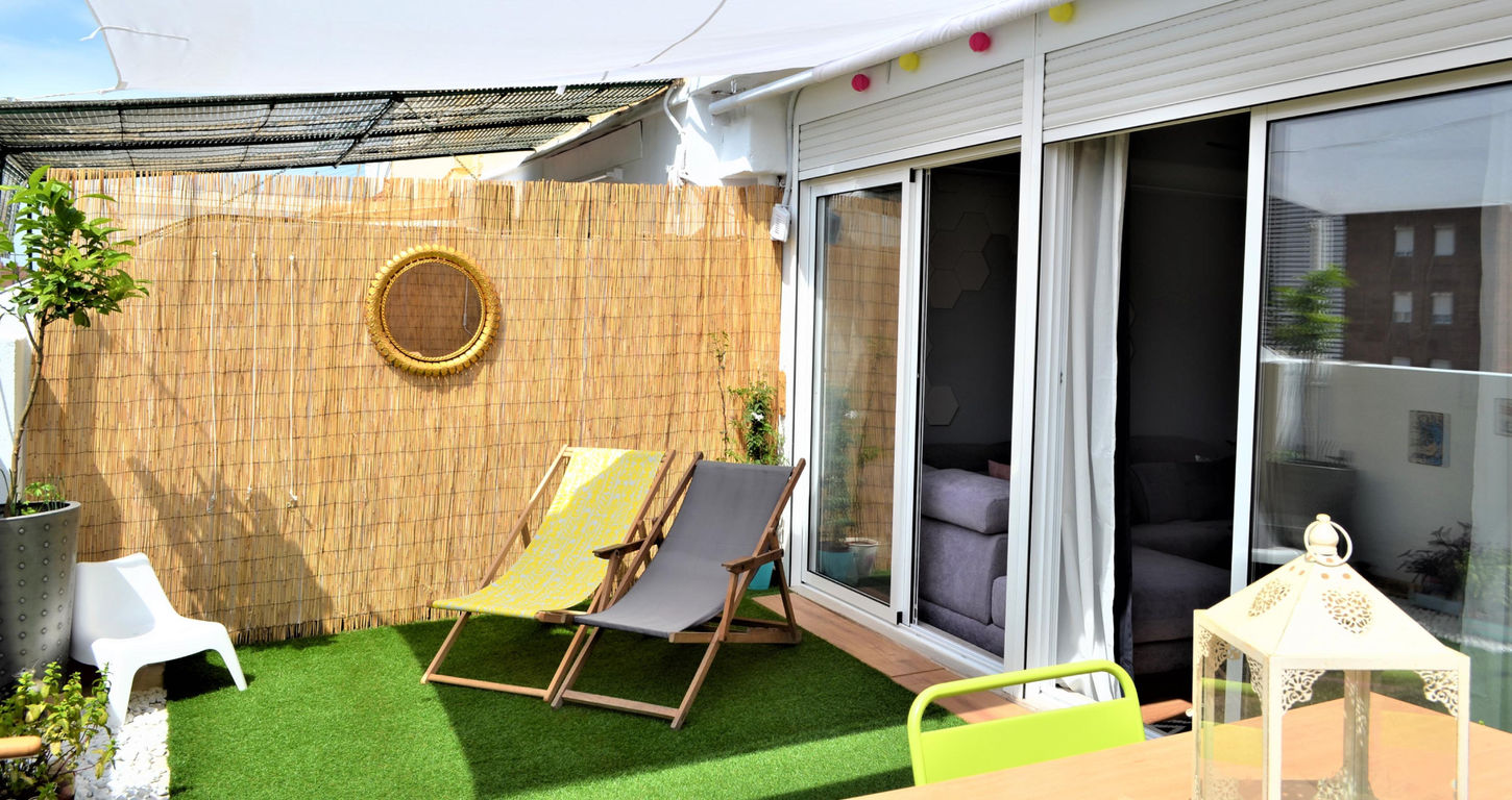 Terraza privada en vivienda unifamiliar reformada con zona de descanso y acceso desde el salón.