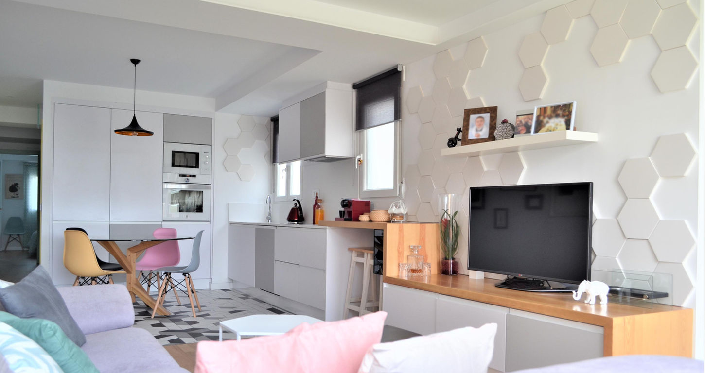 Salón con cocina integrada y mobiliario a medida en vivienda unifamiliar reformada.