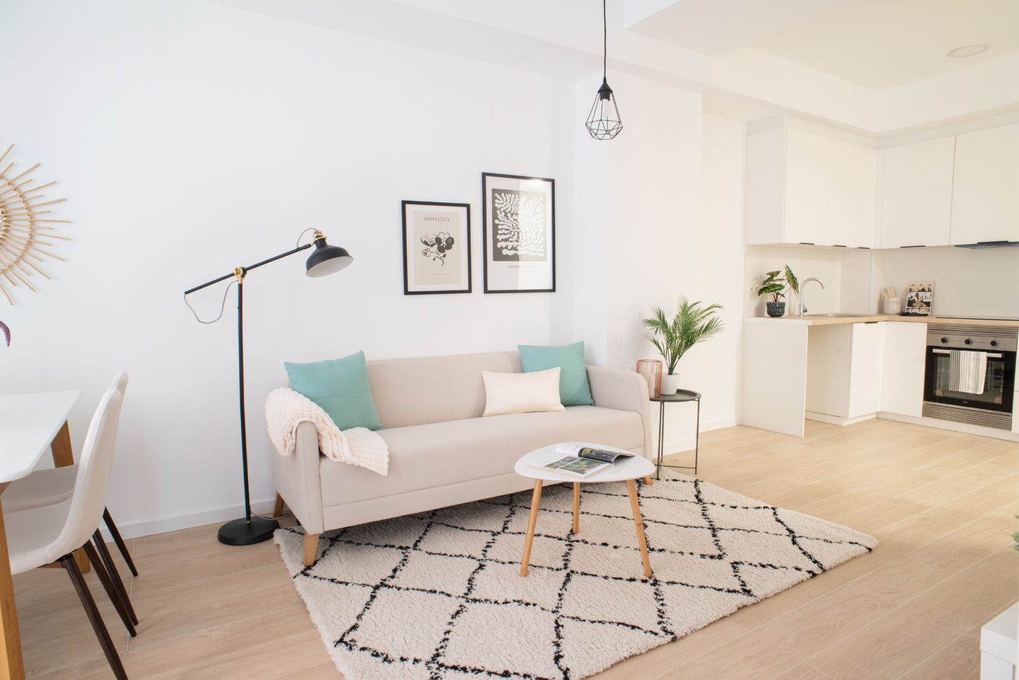 alón moderno con sofá beige, iluminación decorativa y cocina integrada en vivienda unifamiliar reformada por Genovés Calleja Arquitectos.