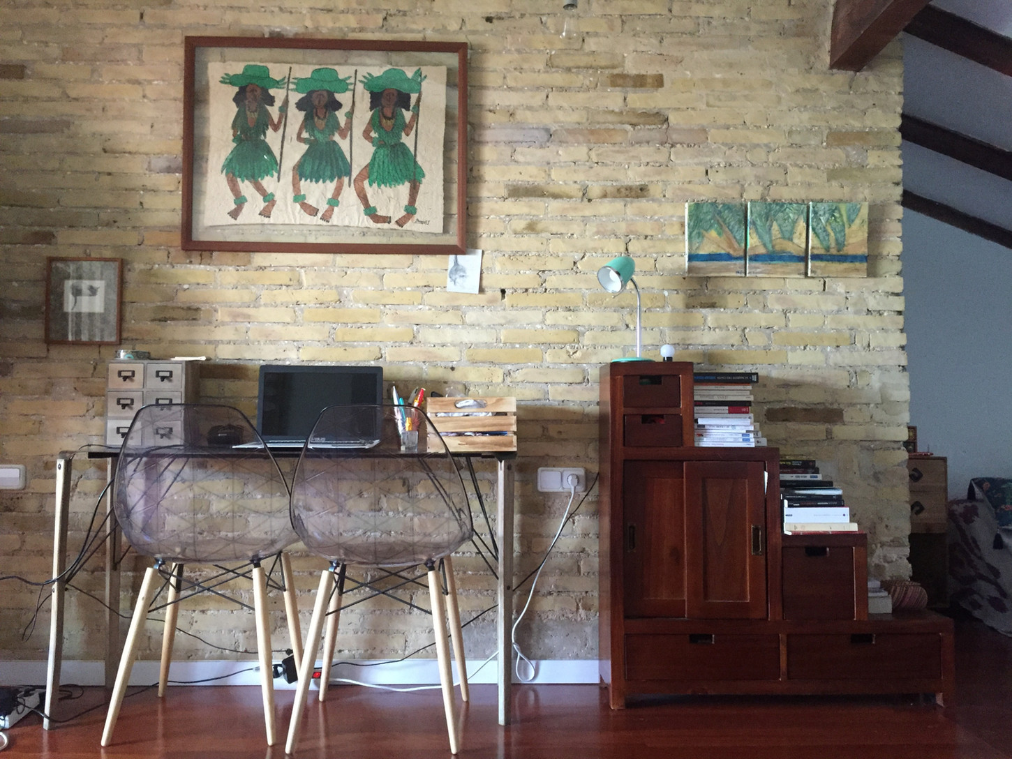 Despacho en vivienda rehabilitada con muro de ladrillo visto y mobiliario contemporáneo.