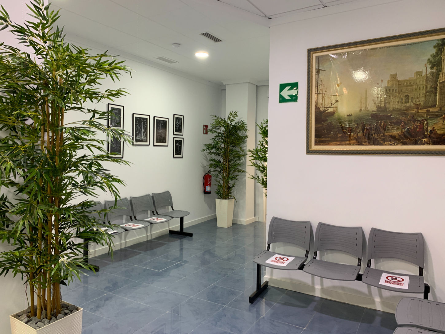 Sala de espera con sillas modulares y plantas decorativas en espacio sanitario diseñado por Genovés Calleja Arquitectos.