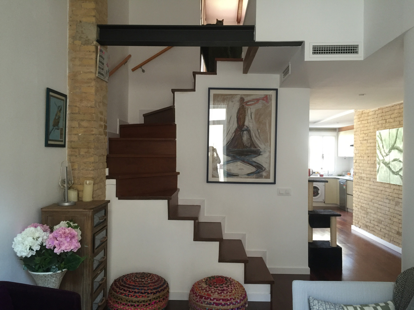Escalera interior con peldaños de madera y estructura metálica en vivienda unifamiliar rehabilitada.