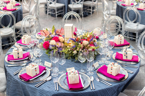 Nighttime gala ambiance with glowing purple lighting, clear tent ceiling, modern wave ceiling décor, and florals.