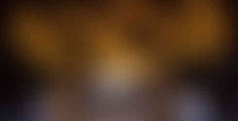 A close-up of chandelier elements, showcasing golden metallic accents and soft glowing lights that create a dazzling effect.