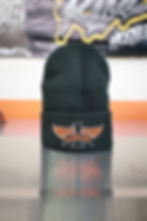 Black knit beanie with Slabsides logo on the cuff, shown in both orange and white embroidery variants