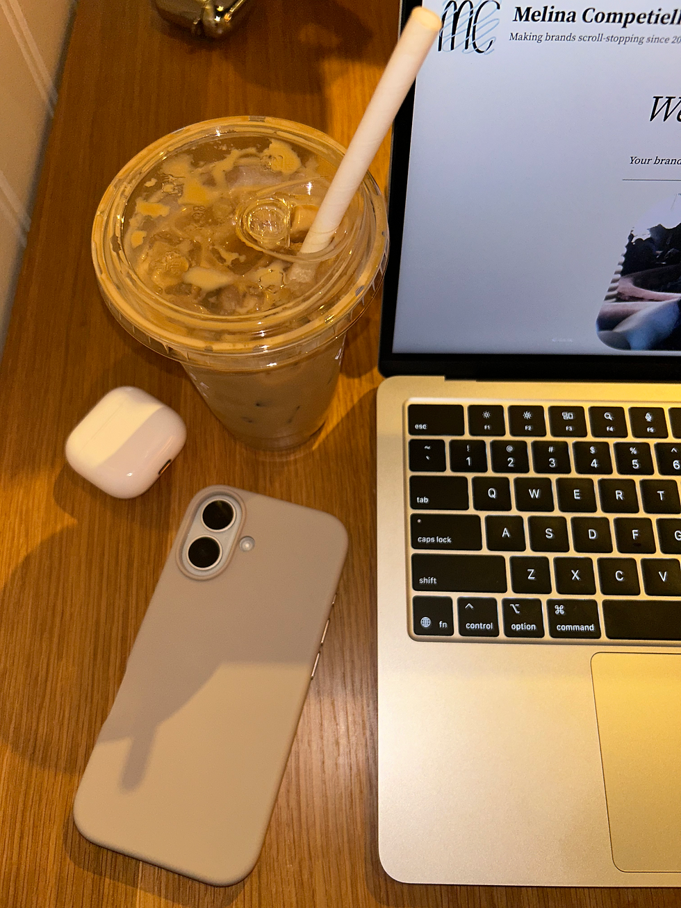 Iced coffee, laptop, and phone on a desk