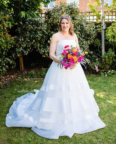 image shows Bride Jo in her beautiful wedding dress with flowers outside