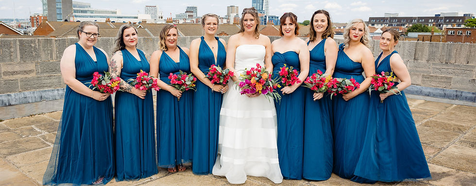 Image shows bride and bridesmaids all wearing teal long multiway dresses with bougainveilla boquetsa