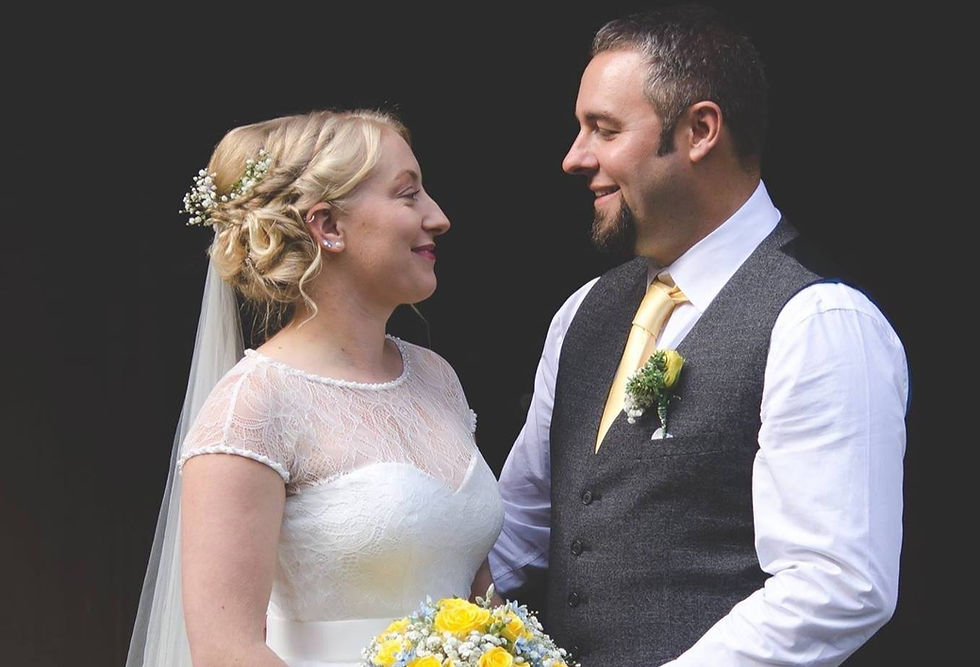 Image shows happy couple on their wedding day looking at each other.