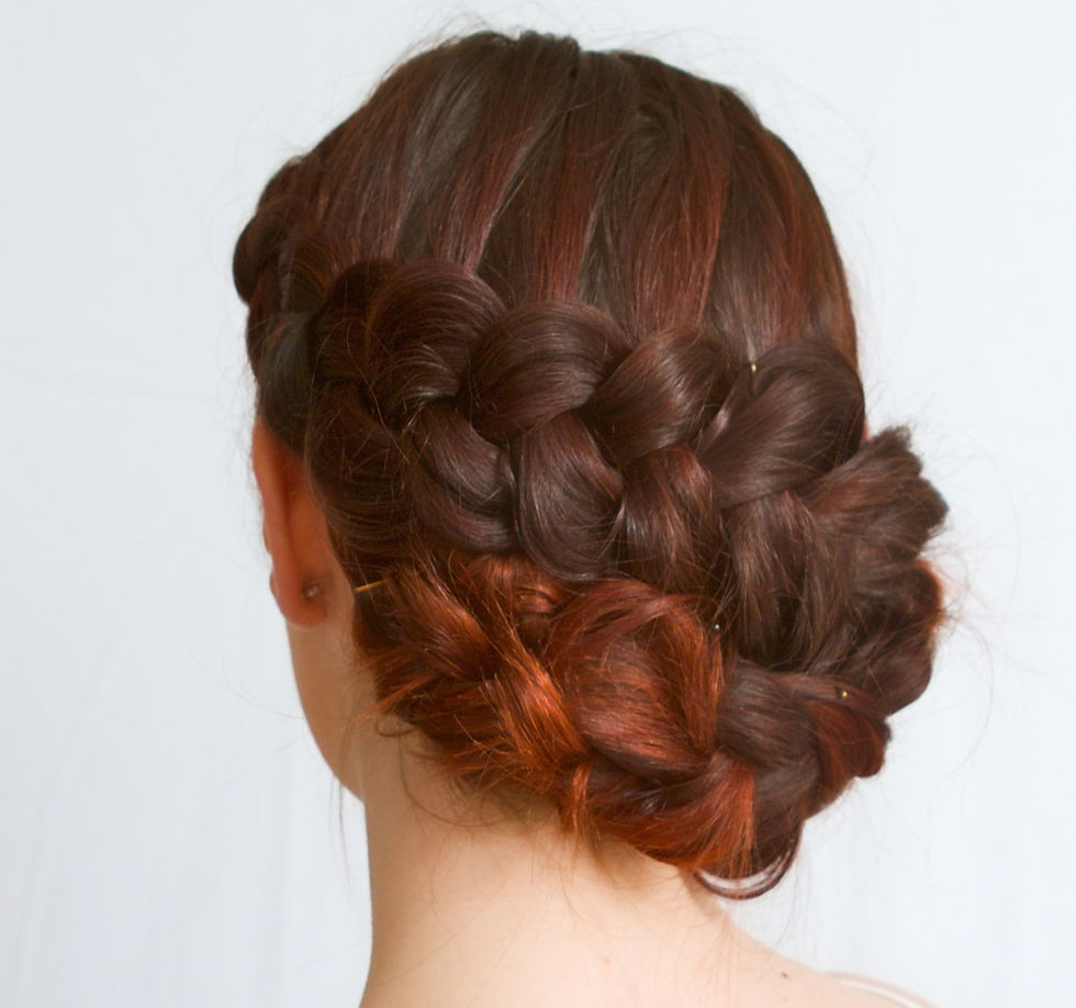 Image shows the back of a brides hair pinned up with plaits