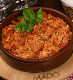 Two scrambled eggs mixed with tomatoes and green peppers.