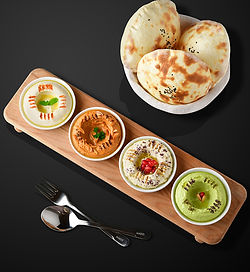 A Mado Specail Cold Delicious Mezza with four flavors are served with bread, Hummus, Mutabel, Pesto Hummus, Sundried Tomato Mouse
