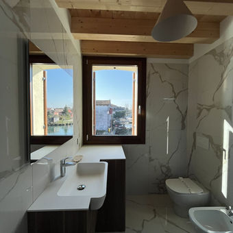 Bagno con mobile lavabo e travi in legno - appartamento arredato a Treviso