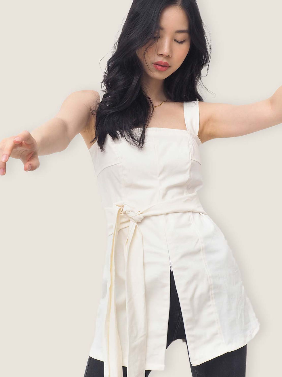 a model wearing a classy square neck top with front zipper details and a waist sash