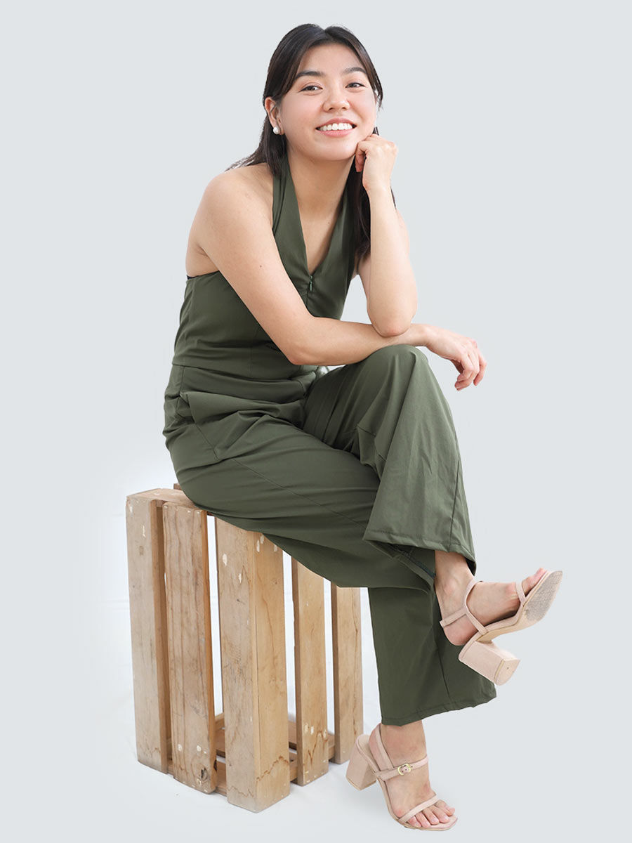 Thumbnail: a model wearing a stylish halter neck jumpsuit with a front zipper