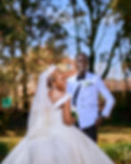 Smiling bride and groom posing outdoors.