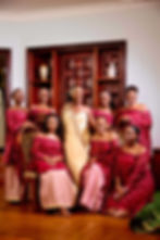 Bride in gold sash with bridesmaids in maroon dresses
