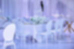 Elegant wedding reception table with white flowers and chairs