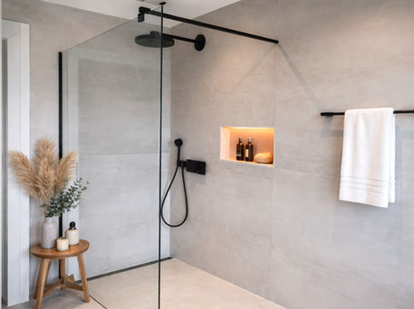 Moderne Dusche nach Badrenovierung mit großen Fliesen