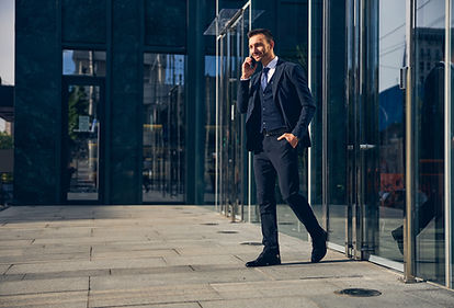 attractive-brunette-businessman-spending-time-outside-business-center-while-speaking-smart