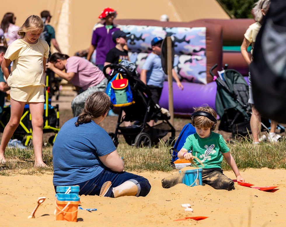 Woman and child playing in a sand pit.