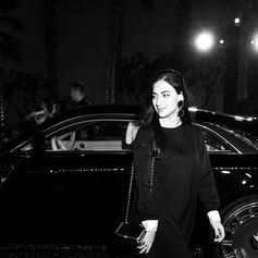 Guest dressed in black posing among customised MANSORY vehicles at night.